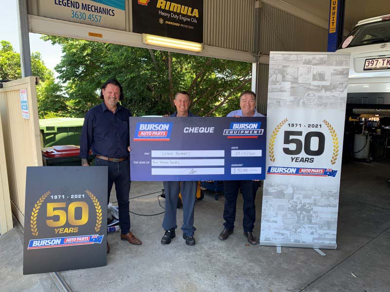 Men holding Burson cheque celebrating 50 years